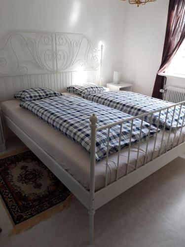 a bed with a blue and white blanket on it at The Old Post Office in Hedenäset
