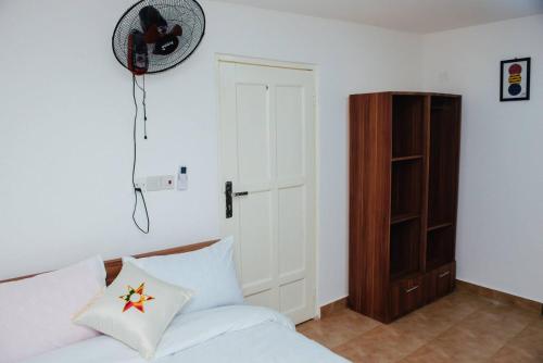 a bedroom with a bed and a fan and a closet at William Ofori-Atta Fie in Accra