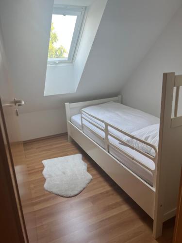 a bedroom with a bed with a white rug and a window at Veens Crew Home 7 Pax in Dreieich