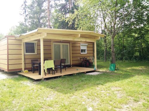 a small cabin with a table and chairs on a deck at Schwimmbad Camping Mössler in Döbriach