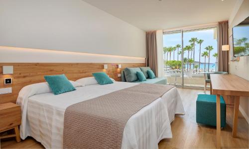 a bedroom with a large bed and a view of the ocean at Hipotels Mediterraneo Club in Sa Coma