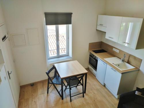 une petite cuisine avec une table et un évier dans l'établissement Joli studio au calme, centre historique de Pertuis, à Pertuis