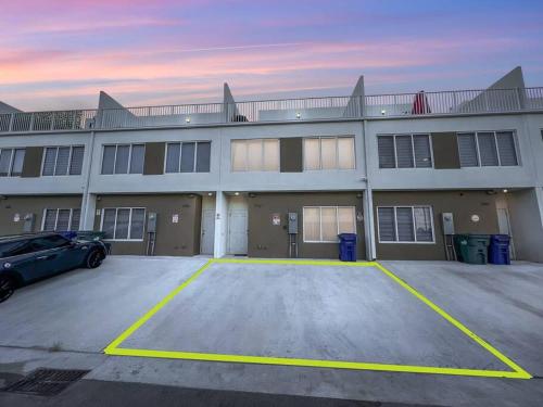 a large building with a car parked in a parking lot at Vacay Spot experience Luna Sky! 65" TV BAR, BBQ, SHOWER massage jets, music, go to FL Keys in Homestead