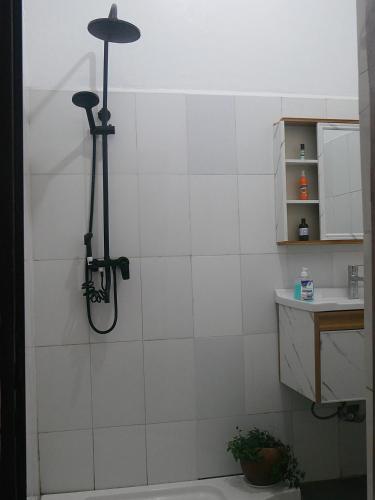 a shower in a bathroom with a white tiled wall at Villa Kikiriki in Kigali