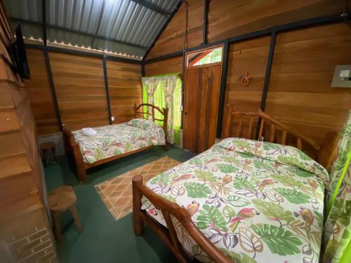 a small room with two beds in a cabin at Guapote Lodge in Tigra