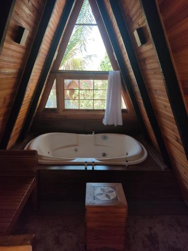 a bathroom with a large window and a bath tub at Pousada Raio de Luz in Pirenópolis