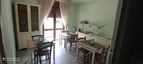 uma cozinha com cadeiras e mesas e uma janela em Al Corso em Montella