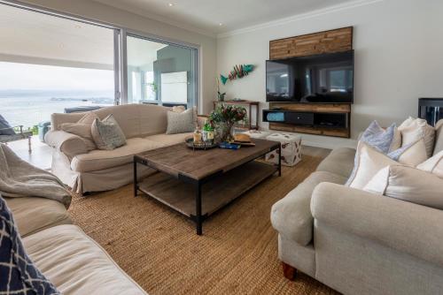 a living room with two couches and a table at Infinity Villa in Knysna