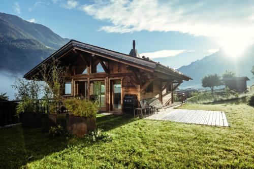 una cabaña en las montañas con el sol en el fondo en Chalet du Rachet Chamonix Mont-Blanc, en Les Houches