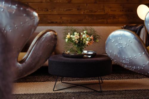 un jarrón con flores en una mesa entre dos pares de zapatos en Chalet du Rachet Chamonix Mont-Blanc, en Les Houches