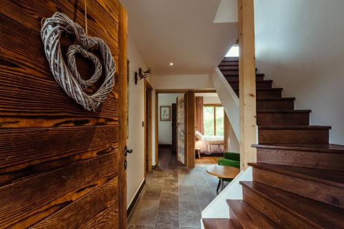 un couloir avec des escaliers et un ornement du cœur sur un mur en bois dans l'établissement Chalet du Rachet Chamonix Mont-Blanc, aux Houches