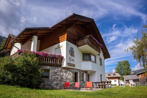 ein Haus mit roten Stühlen davor in der Unterkunft Chalet Fisti in Stern