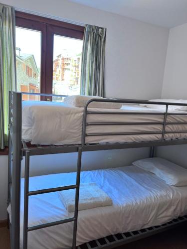 two bunk beds in a room with a window at Pleta 214 in Soldeu