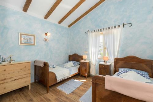 two beds in a room with blue walls at Beautiful villa Natura with pool in Labin in Labin