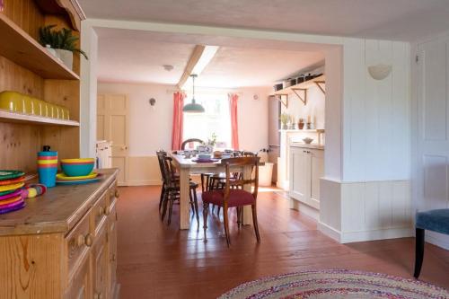 a kitchen and dining room with a table and chairs at Two Sides Cottage in Lymington