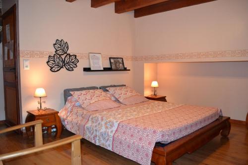 1 dormitorio con 1 cama y 2 mesitas de noche con lámparas en Chambres d'Hôtes Le Moulin à Epices, en Chargey-lès-Gray