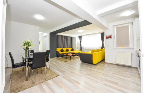 a living room with a yellow couch and a table at Shabbat Apartments in Bucharest