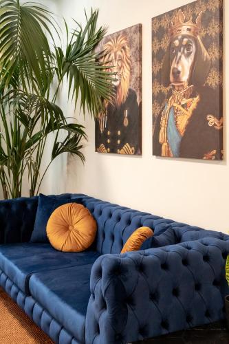a blue couch in a living room with two pictures at PAME Wild in Athens