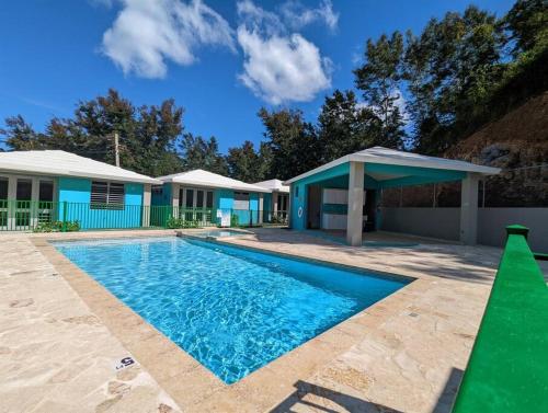 a swimming pool in front of a house at Villas at Chalet De Buye in Cabo Rojo