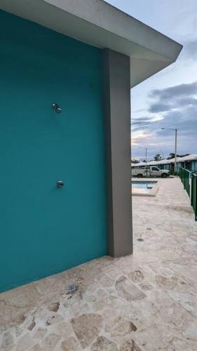 a blue building with a blue wall next to a sidewalk at Villas at Chalet De Buye in Cabo Rojo