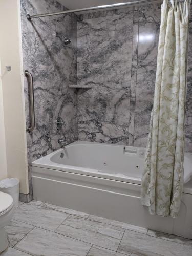 a bathroom with a bath tub and a toilet at Lighthouse Inn in Crescent City