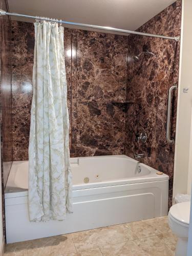 a bathroom with a bath tub and a toilet at Lighthouse Inn in Crescent City