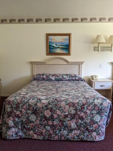 a bedroom with a bed with a floral bedspread at Lighthouse Inn in Crescent City