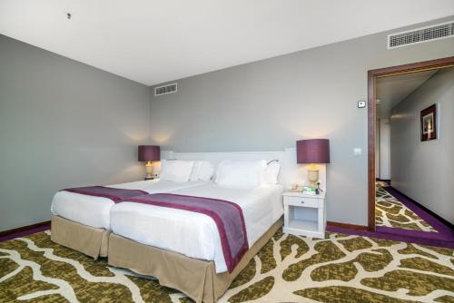 a hotel room with a large bed and a mirror at Holiday Inn Porto Gaia by IHG in Vila Nova de Gaia
