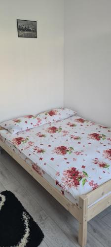 uma cama com flores num quarto em Sofia Apartments em Gherla