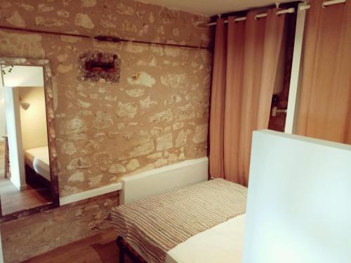 une petite chambre avec un lit et un miroir dans l'établissement Le petit pré écolo, à Longué