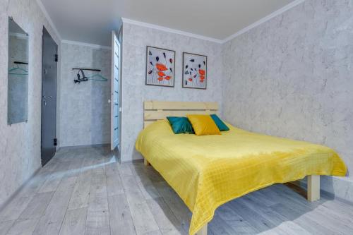 a bedroom with a bed with a yellow blanket on it at YourHouse на Розыбакиева Утепова недалеко от Меги in Almaty