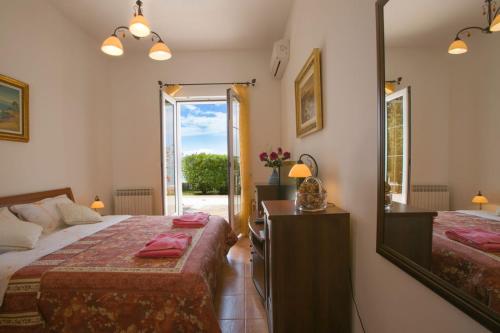 a bedroom with two beds and a mirror at Royal Holiday Apartments Sveti Stefan in Sveti Stefan