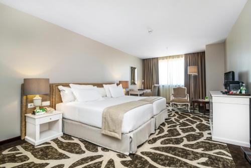 a hotel room with a bed and a desk at Holiday Inn Porto Gaia by IHG in Vila Nova de Gaia