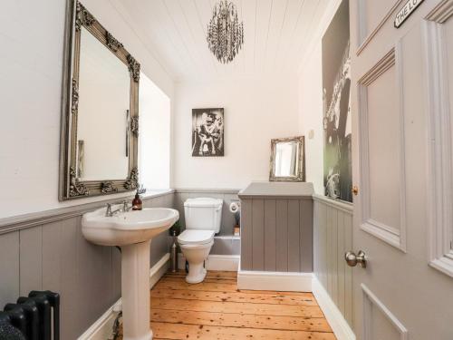 uma casa de banho com um lavatório, um WC e um espelho. em Noah's Barn em Poulton le Fylde