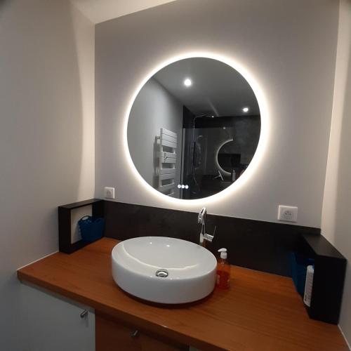 a bathroom with a white sink and a mirror at Maupy in Ploemeur