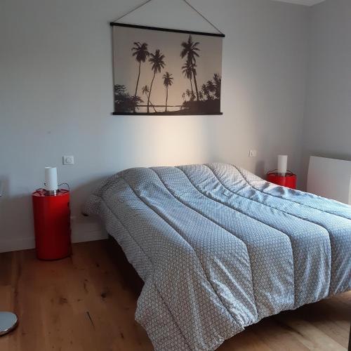 a bedroom with a bed with palm trees on the wall at Maupy in Ploemeur