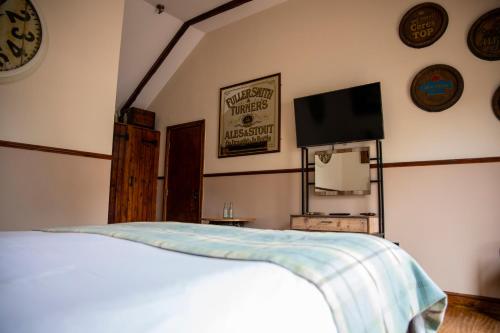 a bedroom with a bed and a flat screen tv at South Causey Inn in Stanley