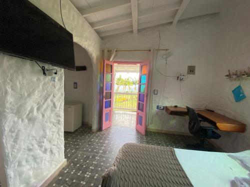 a room with a bed and a colorful door at Cabañas y Flores in Jericó