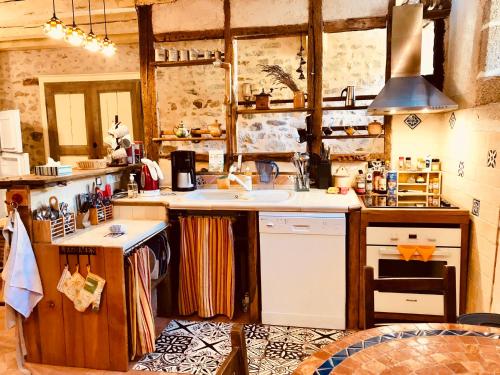 a kitchen with a sink and a stove at Gite Saint-Nicolas in Parthenay