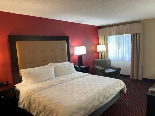 a hotel room with a large bed and a chair at Wyndham Garden Dover in Dover