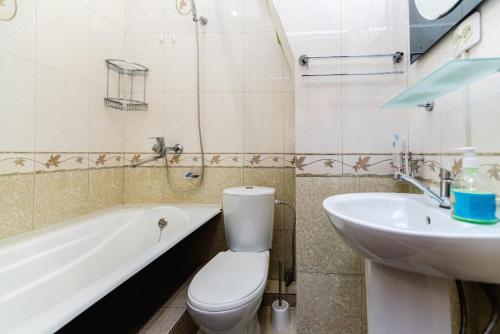 La salle de bains est pourvue de toilettes blanches et d'un lavabo. dans l'établissement Книжный Город, à Almaty