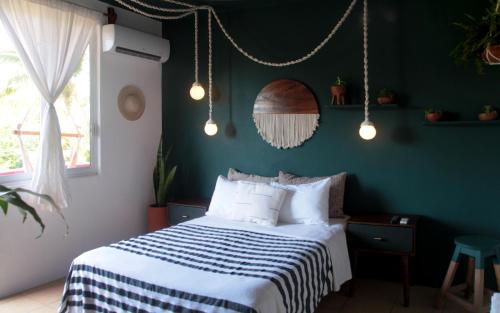 a bedroom with a bed and a green wall at Hotel San Martin La Punta in Puerto Escondido