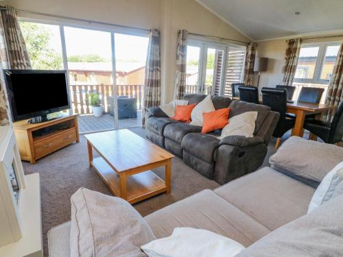 a living room with a couch and a flat screen tv at Gressingham 22 in Carnforth