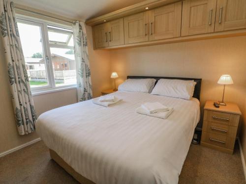 1 dormitorio con 1 cama blanca grande y ventana en Gressingham 22, en Carnforth
