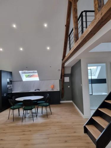 une salle à manger avec une table et des chaises et un escalier dans l'établissement Petit Nid Douillet, à Solre-le-Château