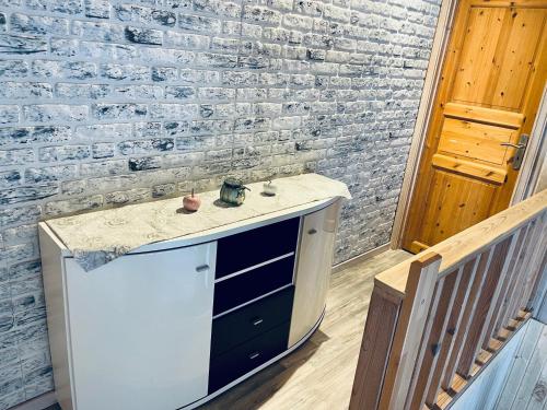 a kitchen with a sink and a brick wall at PREMIUM-Ferienhaus für 5 Gäste - Sauna, Wald u. Berge Extertal-Ferienpark #49 in Extertal