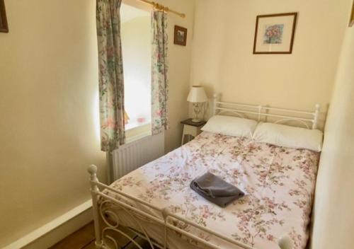 un dormitorio con una cama con un bolso en Bluebell Cottage, en Grassington