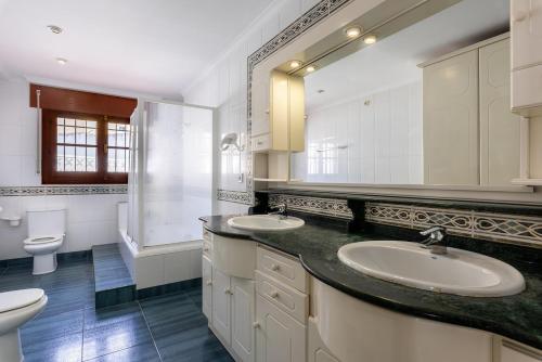 a bathroom with two sinks and a large mirror at Villa espectacular in Rincón de la Victoria