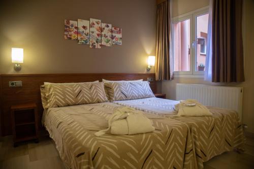 Hotel & Spa Can Josep في Bot: غرفة نوم عليها سرير وفوط