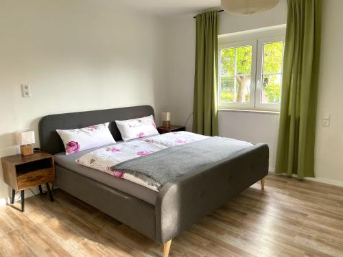 Schlafzimmer mit einem Bett und einem Fenster in der Unterkunft Kelsbachhaus EG in Pförring